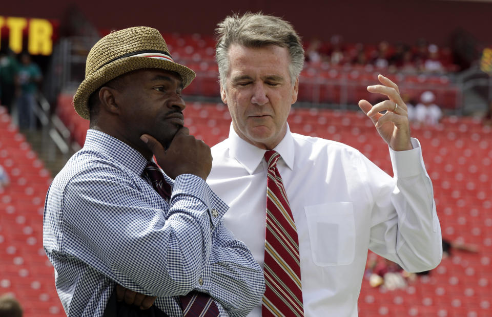 DeMaurice Smith, left, executive director of the National Football League Players' Association talks with Bruce Allen, Washington Redskins president, before an NFL football game against the Miami Dolphins,  Sunday, Sept. 13, 2015, in Landover, Md. (AP Photo/Mark Tenally)