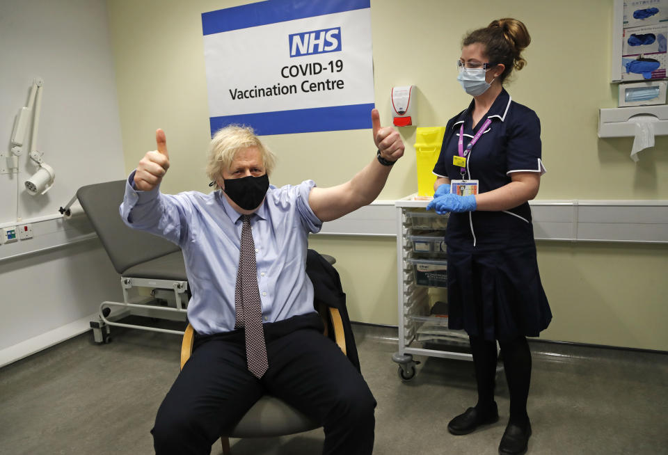 FILE - In this Friday, March 19, 2021 file photo Britain's Prime Minister Boris Johnson gestures after receiving the first dose of the AstraZeneca vaccine administered by nurse and Clinical Pod Lead, Lily Harrington at St.Thomas' Hospital in London. (AP Photo/Frank Augstein, Pool)