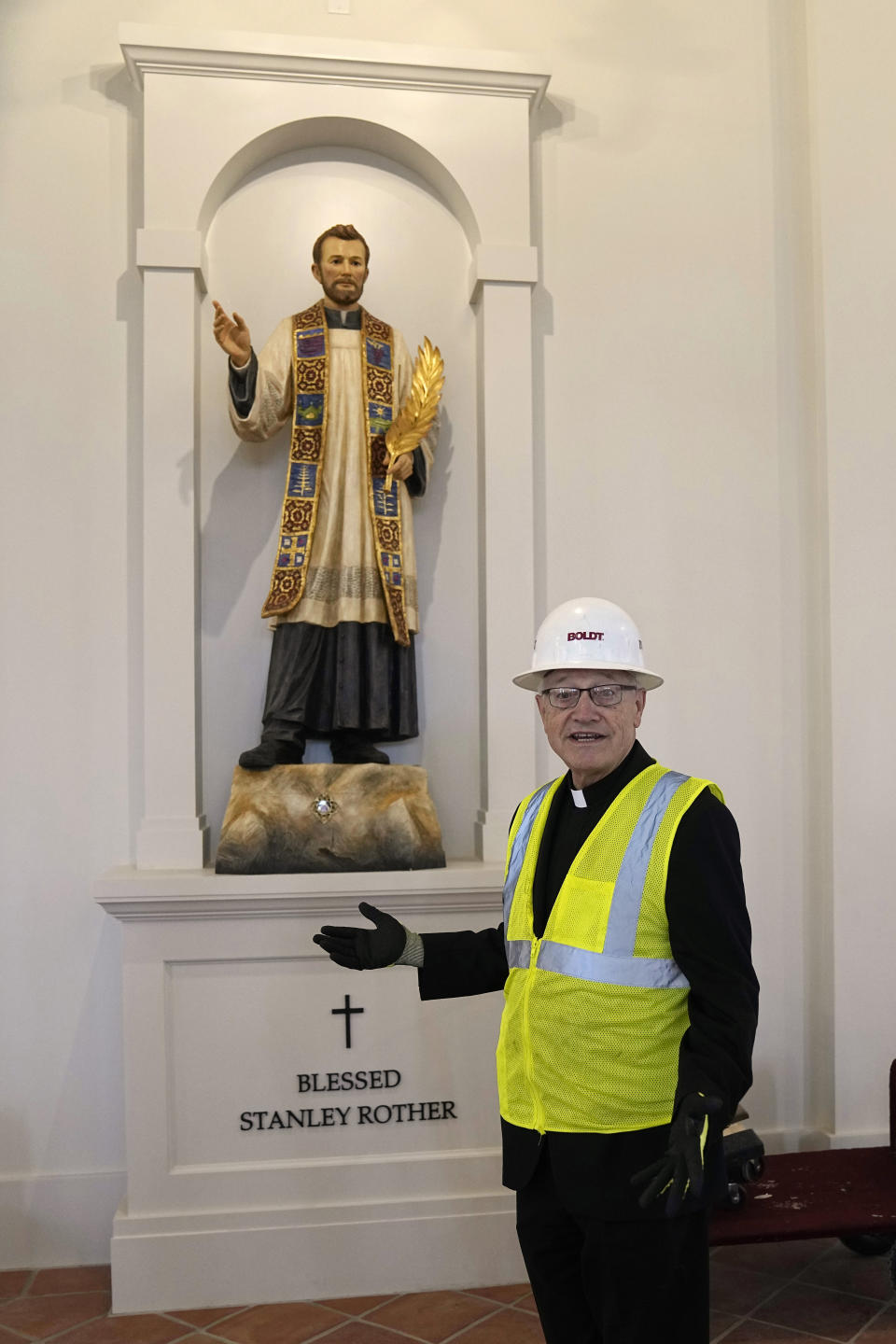 Rev. Don Wolf, a cousin of the Blessed Stanley Rother, stands by a statue of Rother in a chapel at the Blessed Stanley Rother Shrine, Thursday, Feb. 2, 2023, in Oklahoma City. Wolf will serve as the shrine's first rector. (AP Photo/Sue Ogrocki)