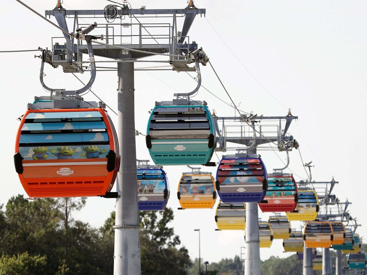 Firefighters have responded to help Walt Disney World holiday-goers who have been stuck aboard the Florida resort's newly launched aerial cable car system: AP Photo/John Raoux