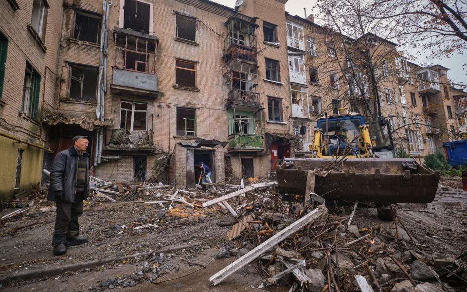 Trabajadores limpian los escombros de un edificio residencial dañado en un bombardeo nocturno en la pequeña ciudad de Druzhkivka en el área de Donetsk en Ucrania - Shutterstock