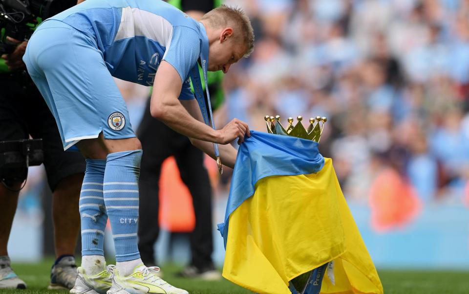 Oleksandr Zinchenko celebrates with a Ukrainian flag and the Premier League trophy - Stu Forster/Getty Images