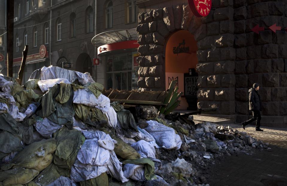 A man walks past along a road which leads Kiev's Independence Square, Ukraine, Saturday, March 8, 2014. (AP Photo/David Azia)