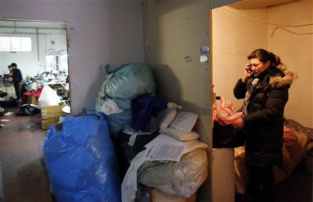 A Chinese immigrant makes a phone call as police officers conduct a check at the Shen Wu textile factory in Prato December 9, 2013. REUTERS/Stefano Rellandini