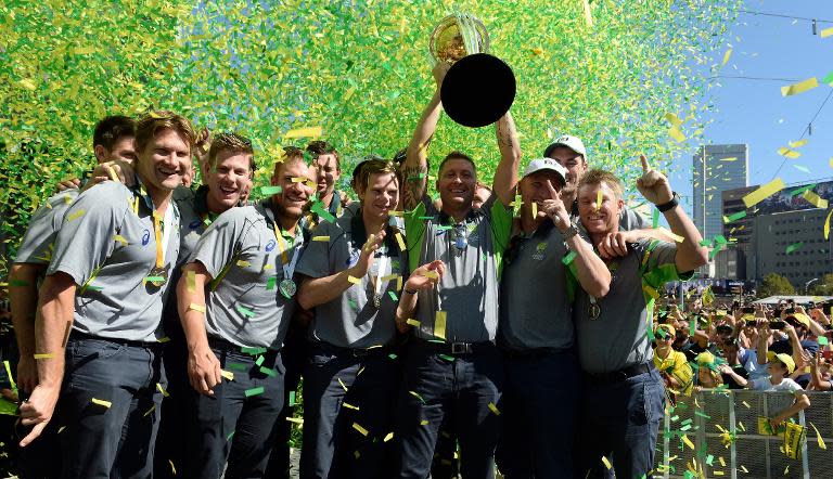 Australia's captain Michael Clarke holds the Cricket World Cup trophy as he poses with the team during a public event to celebrate their victory, in Melbourne, on March 30, 2015