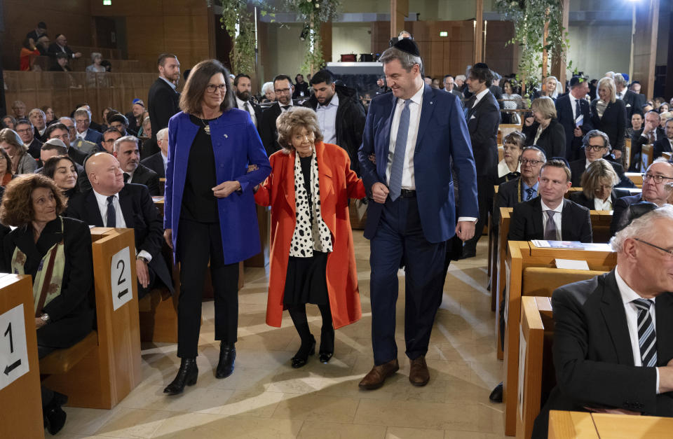 Ilse Aigner, from left, (CSU), President of the Bavarian State Parliament, Charlotte Knobloch, President of the Jewish Community of Munich and Upper Bavaria, and Markus Soder, Prime Minister of Bavaria, take part in a ceremony and commemoration of the 20th anniversary of the main synagogue "Ohel Jakob" and the pogrom night, in Munich, Germany, Thursday, Nov. 9, 2023. On the 85th anniversary of Kristallnacht today, Knobloch still remembers that night with horror and says it will be burned into her memory forever. (Sven Hoppe/dpa via AP)