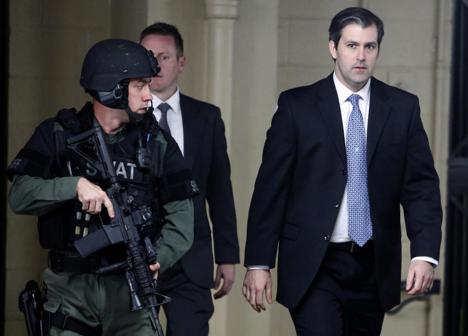 FILE- In this Dec. 5, 2016 file photo, Michael Slager, at right, walks from the Charleston County Courthouse under the protection from the Charleston County Sheriff's Department after a mistrial was declared for his trial in Charleston, S.C. Slager, a former South Carolina police officer serving 20 years in prison for killing an unarmed Black man who was running away from a traffic stop, said his lawyer never told him about a plea offer from prosecutors that could have cut years off his sentence. He is requesting a new sentence in federal court this week. (AP Photo/Mic Smith, File)