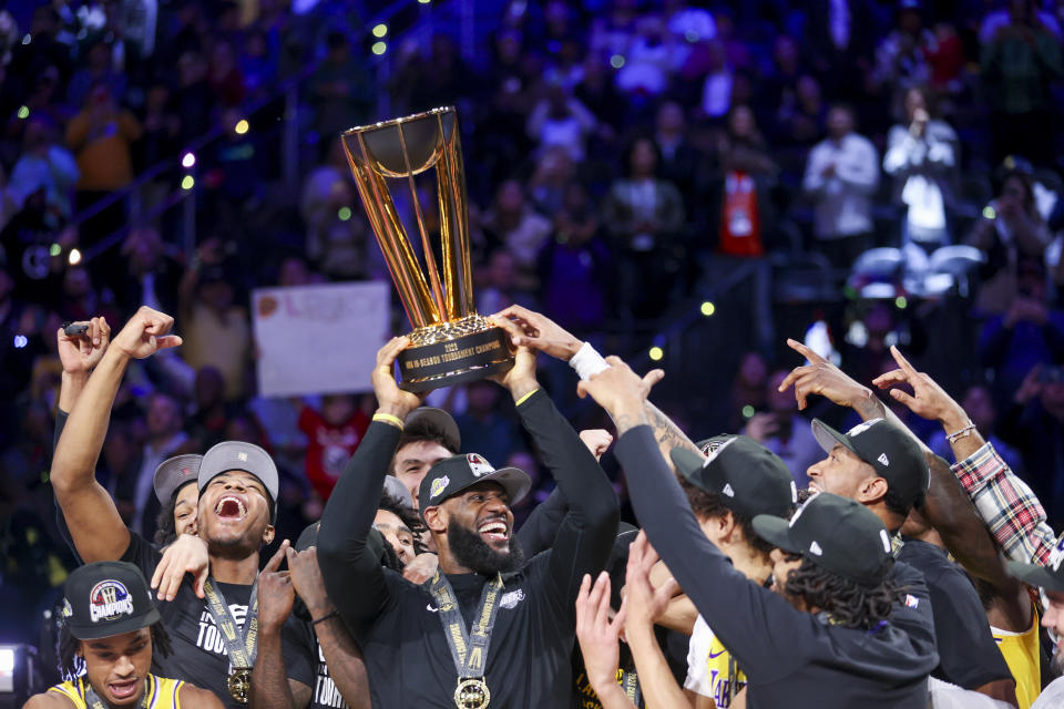 Los Angeles Lakers forward LeBron James, center, lifts the the NBA Cup while celebrating with teammates after they defeated the Indiana Pacers 123-109 in the championship game in the NBA basketball In-Season Tournament on Saturday, Dec. 9, 2023, in Las Vegas.(AP Photo/Ian Maule)