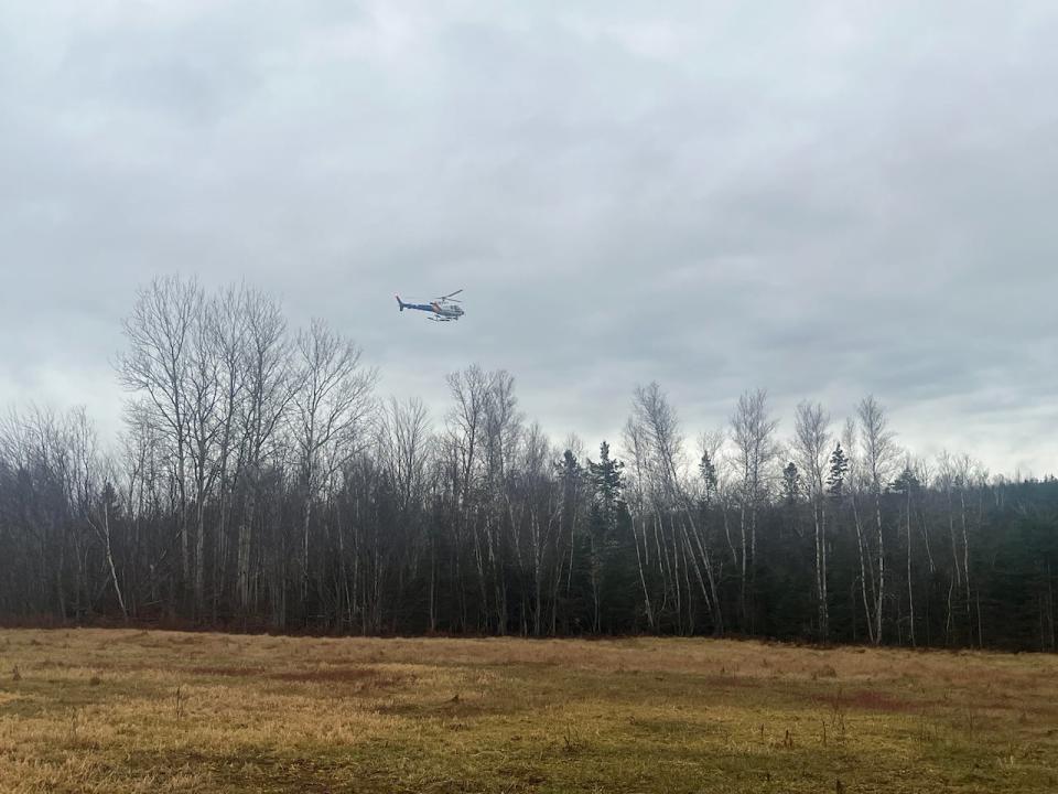 An RCMP helicopter flies over the Greek River Road area in eastern P.E.I. on Tuesday.