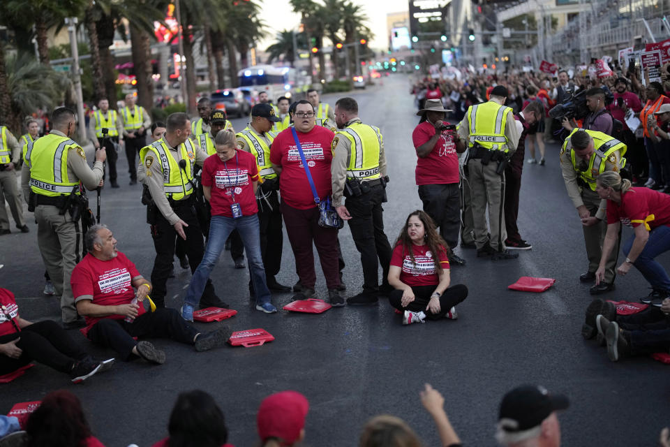 Police arrest members of the Culinary Workers Union along the Strip, Wednesday, Oct. 25, 2023, in Las Vegas. Thousands of hotel workers fighting for new union contracts rallied Wednesday night on the Las Vegas Strip, where rush-hour traffic was disrupted when some members blocked the road before being detained by police. (AP Photo/John Locher)
