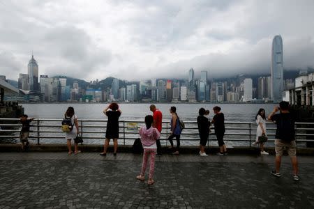 People gather at a waterfront as Typhoon Roke approaches Hong Kong, China July 23, 2017. REUTERS/Bobby Yip