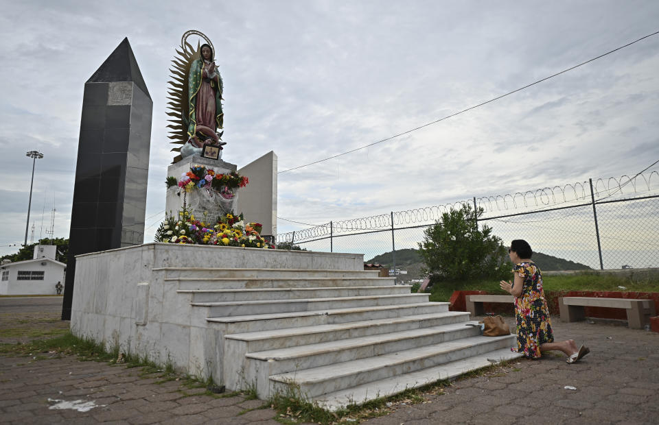 A woman prays in front of an image of the Virgin of Guadalupe, prior the landfall of tropical storm Pamela, in Mazatlan, Mexico, Tuesday, Oct. 12, 2021. Hurricane Pamela weakened to a tropical storm Tuesday afternoon as it meandered off Mexico's Pacific coast. Forecasters said it was expected to regain strength overnight and be a hurricane when making landfall somewhere near the port of Mazatlan Wednesday. (AP Photo/Roberto Echeagaray)