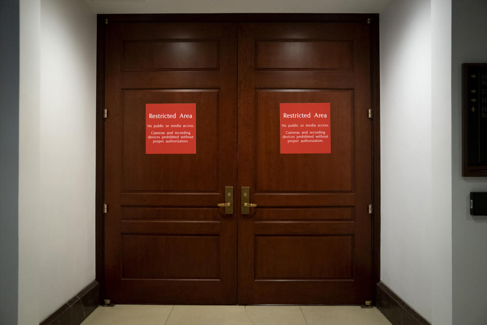 FILE - Bright red signs alert non-authorized personnel at the entrance to the House SCIF, the Sensitive Compartmented Information Facility, located three levels beneath the Capitol where witnesses and lawmakers hold closed interviews in the impeachment inquiry on President Donald Trump's efforts to press Ukraine to investigate his political rivals, in Washington, Nov. 6, 2019. When members of Congress want to peruse classified materials, they descend deep into the basement of the Capitol to a sensitive compartmented information facility, known as a SCIF. (AP Photo/J. Scott Applewhite, File)