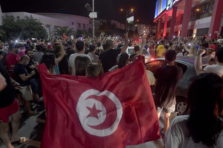 La gente celebra en la calle después de que el presidente tunecino Kais Saied anunciara la disolución del parlamento y del gobierno del primer ministro Hichem Mechichi