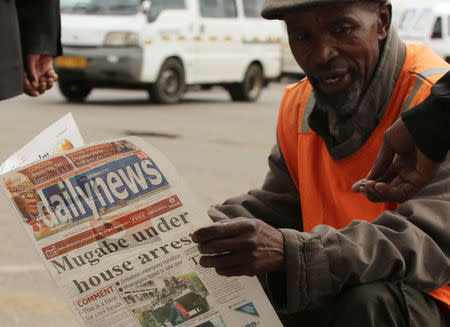 A street vendor reads a newspaper in central Harare, Zimbabwe, November 16,2017. REUTERS/Philimon Bulawayo
