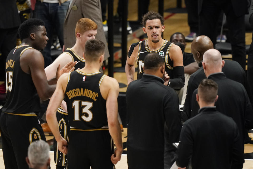 Atlanta Hawks guard Trae Young (11) and teammates huddle at the bench during the second half of Game 4 of a second-round NBA basketball playoff series against the Philadelphia 76ers, Monday, June 14, 2021, in Atlanta. (AP Photo/Brynn Anderson)