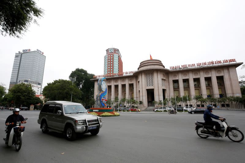 FILE PHOTO: People go past the State Bank building in central Hanoi