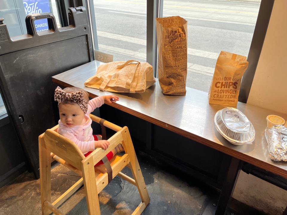 tiffany's daughter sitting in a height chair at chipotle