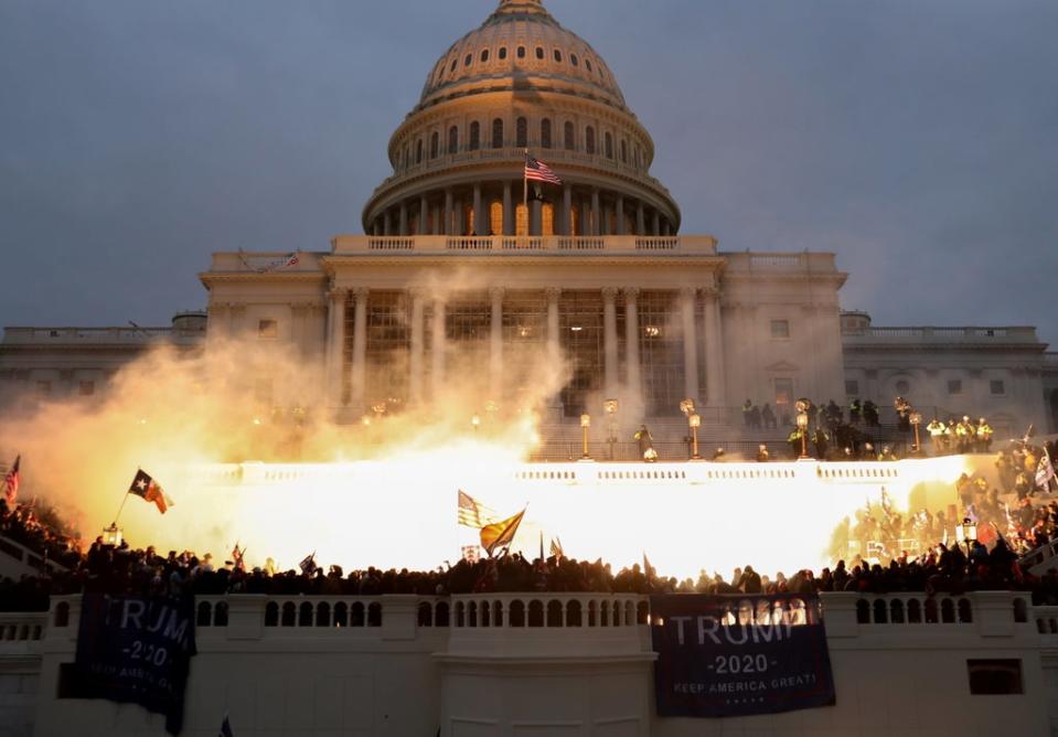 Hundreds of alleged Trump supporters encircled the US Capitol Building on 6 January, as police munition caused a  flame – lighting up the crowd. (REUTERS)
