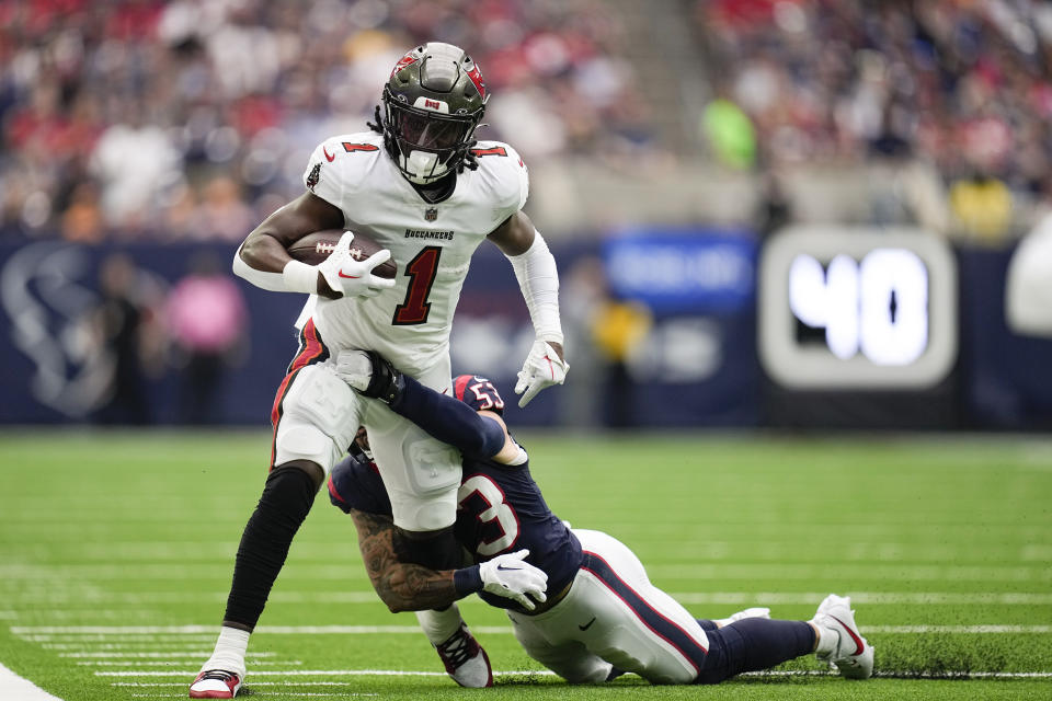Tampa Bay Buccaneers running back Rachaad White (1) runs with the ball after making a catch as Houston Texans linebacker Blake Cashman (53) tries to bring him down during the first half of an NFL football game, Sunday, Nov. 5, 2023, in Houston. (AP Photo/Eric Gay)