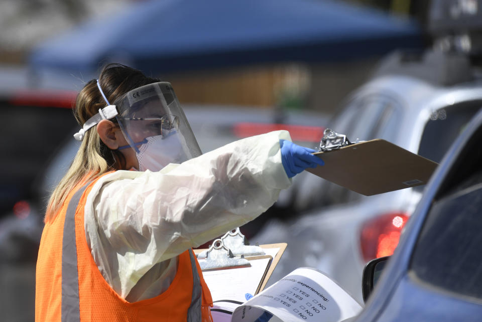 A medical provider passes necessary paperwork to a patient at the STRIDE Community Health Center's COVID-19 drive-thru testing site at the Aurora Health and Wellness Plaza March 26, 2020. (Photo: Andy Cross/MediaNews Group/The Denver Post via Getty Images) 