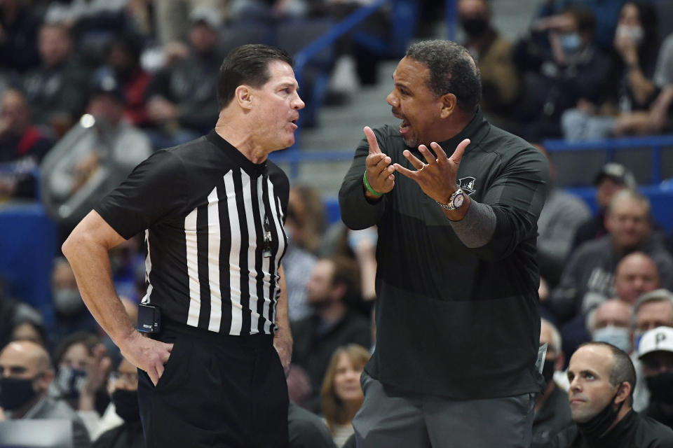 Providence head coach Ed Cooley, right, argues with official Wally Rutecki in the first half of an NCAA college basketball game against Connecticut, Saturday, Dec. 18, 2021, in Hartford, Conn. (AP Photo/Jessica Hill)