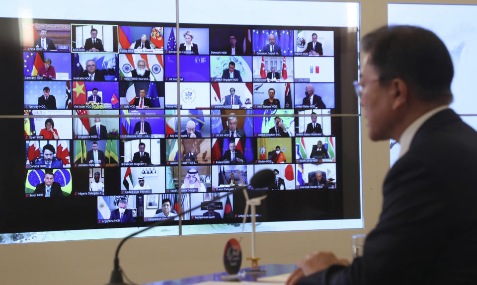 South Korean President Moon Jae-in, right, speaks as the screen showing world leaders at the virtual Leaders Summit on Climate, at the presidential Blue House in Seoul, South Korea, Thursday, April 22, 2021. (Lee Jin-wook/Yonhap via AP)