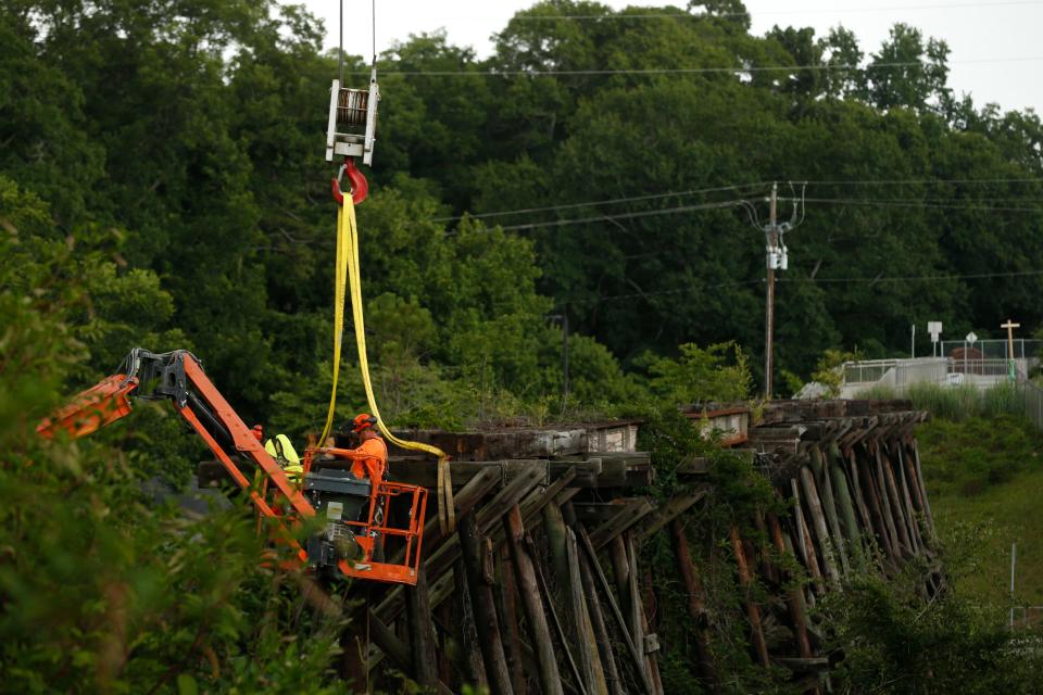 FILE - Workers remove sections of the iconic R.E.M. railroad trestle in Athens, Ga., on Wednesday, July 7, 2021. The railroad trestle appeared on the cover of R.E.M.'s 1983 debut album "Murmur” and was planned to be re-incorporated as part of the Firefly Trail when a steel arch bridge is constructed. The structure’s conditions were deemed too poor to keep as an original feature.