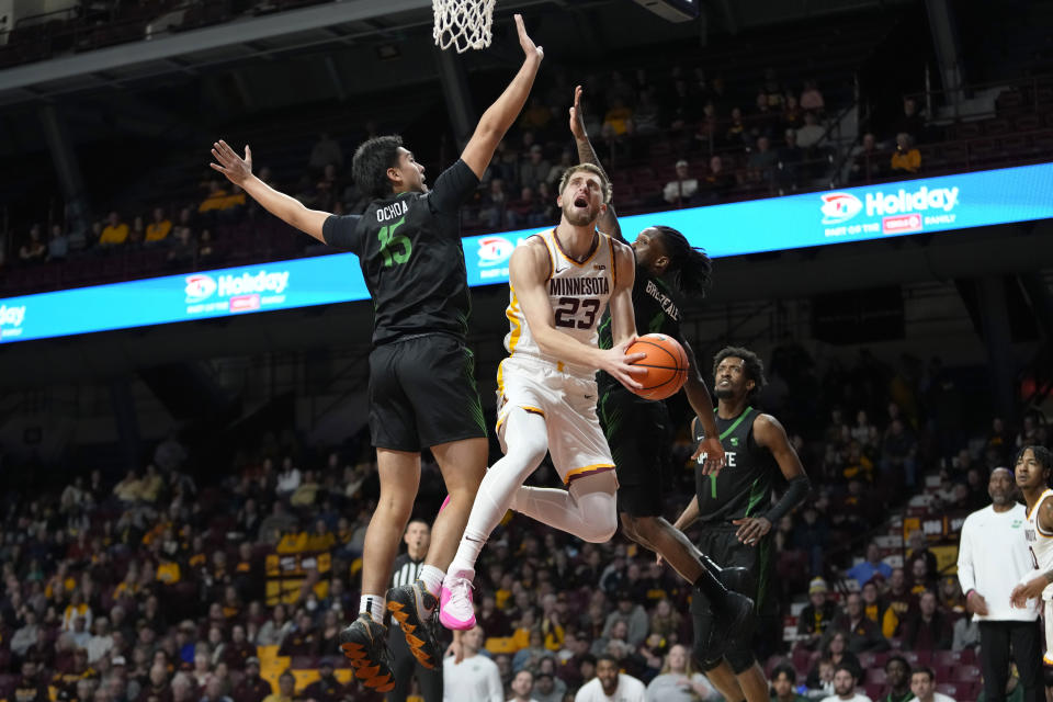 Minnesota forward Parker Fox (23) goes up for a shot as USC Upstate guard Jorge Ochoa (15) and guard Jalen Breazeale, right, defend during the first half of an NCAA college basketball game, Saturday, Nov. 18, 2023, in Minneapolis. (AP Photo/Abbie Parr)