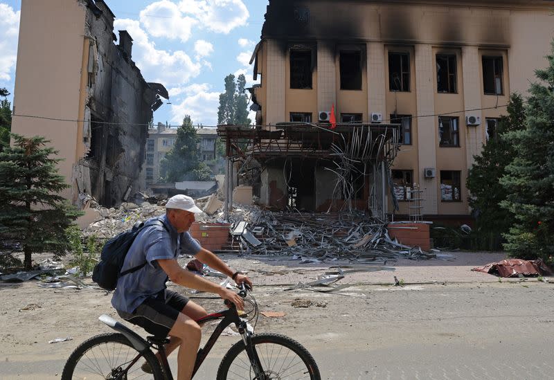 Un residente local pasa en bicicleta por delante del edificio del ayuntamiento destruido durante el conflicto entre Ucrania y Rusia en la ciudad de Lisichansk, en la región de Luhansk, Ucrania