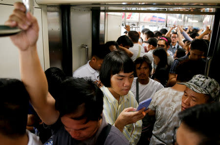 Oliver Emocling, 23, who works for a magazine, uses his phone on the train going to work in Manila, Philippines, November 29, 2018. Emocling often uses his travel time to read the news or draft his first article for the day. "Sometimes I really have to bring my work or my rest into my commute," he said. REUTERS/Eloisa Lopez