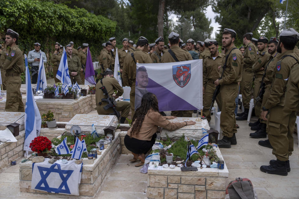 Israeli soldiers and family members of fallen soldiers visit their graves on the eve of the country's annual Memorial Day for fallen soldiers and victims of nationalistic attacks at Mount Herzl military cemetery in Jerusalem, Sunday, May 12, 2024. (AP Photo/Ohad Zwigenberg)
