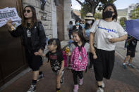 Emily Ku, right, joins a protest against the use of tear gas with her sister Kari Ku, left, and their children in Hong Kong Saturday, Nov. 23, 2019. Chanting "No more tear gas," dozens of Hong Kong families with young children are marching to oppose the government's handling of protests on the eve of keenly contested local elections. (AP Photo/Ng Han Guan)