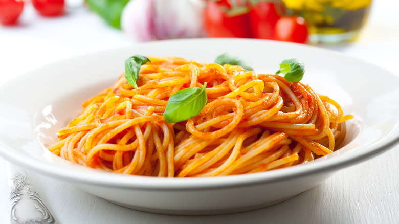 Spaghetti al pomodoro with basil in white bowl