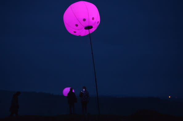 Members of the public view the art installation New York based digital arts collective YesYesNo with founding member Zachary Lieberman, Connecting Light which is part of the London 2012 Festival on August 31, 2012 in Hexham, England. Connecting Light will take place across the 73 miles of Hadrian's Wall on August 31 and September 1. Over 400 two metre diameter tethered balloons will transmit messages between each other, with internal LED lights changing colour in response. The installation becomes a line of pulsating colours as messages travel through it, turning what was once a protective border into a line of luminous communication. The installation will be visible in the evening and accessible to visitors at several locations along the wall. It has also been designed to be viewed remotely all over the world using digital media. (Photo by Jeff J Mitchell/Getty Images)