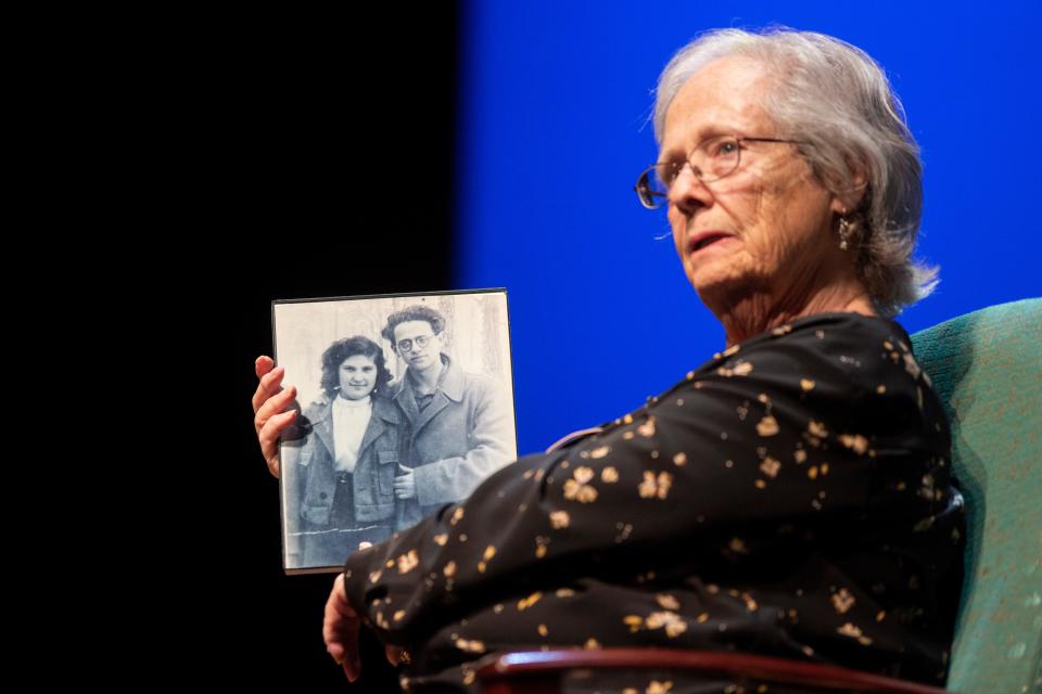 Rachel Turet, daughter of Holocaust survivor Ester Basch, holds up a photo of her parents on Sunday, March 26, 2023, at NMSU Center for the Arts. 