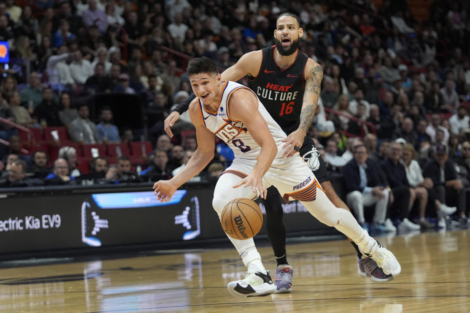 Phoenix Suns guard Grayson Allen (8) drives to the basket past Miami Heat forward Caleb Martin (16) during the first half of an NBA basketball game, Monday, Jan. 29, 2024, in Miami. (AP Photo/Wilfredo Lee)