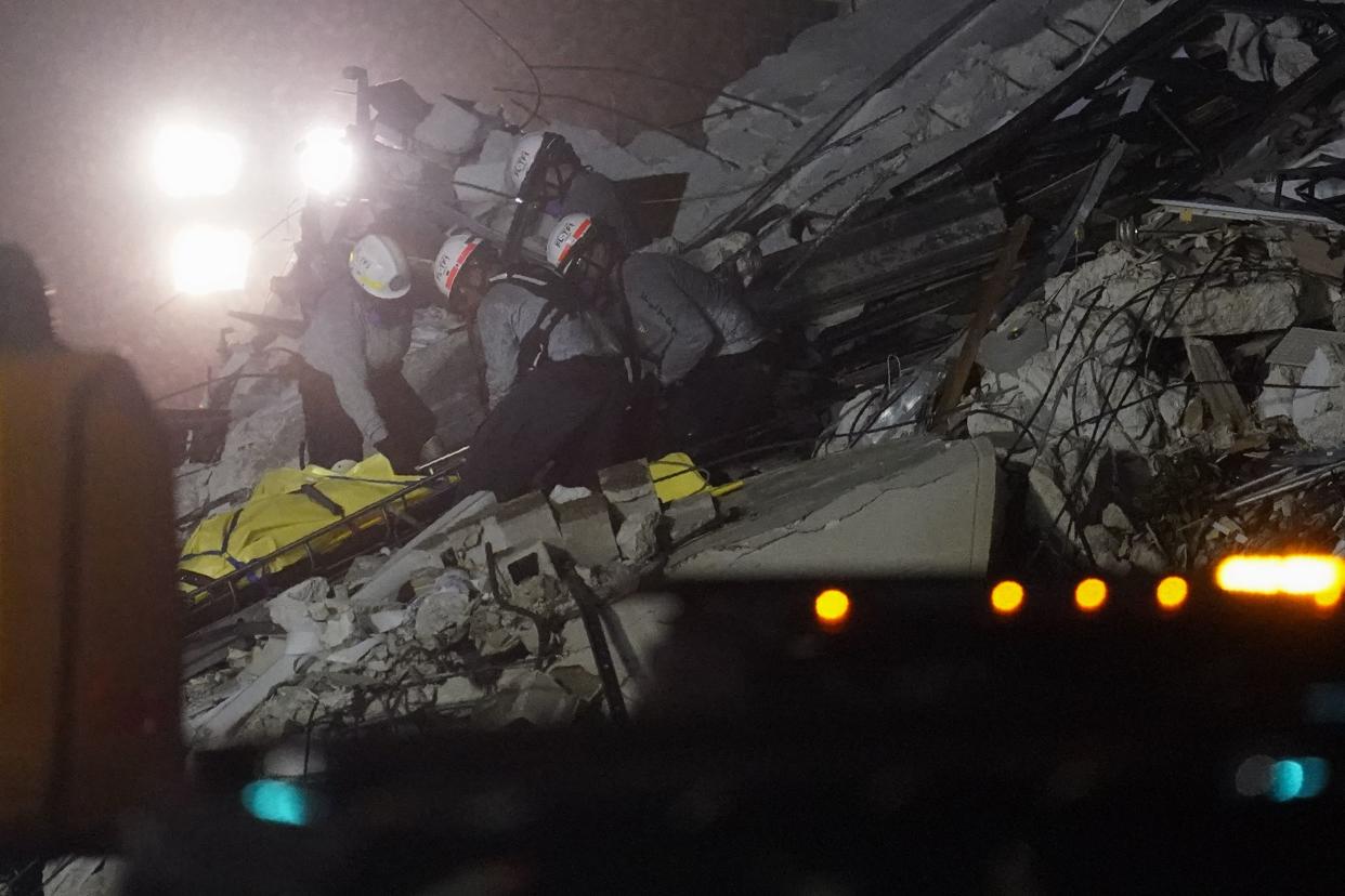 Rescue workers remove a body from the rubble where a wing of a 12-story beachfront condo building collapsed, Thursday, June 24, 2021, in the Surfside area of Miami.
