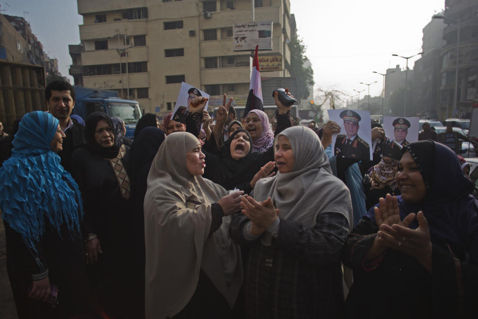 Egyptians chant slogans while holding pictures of Egypt's Defense Minister, Gen. Abdel-Fattah el-Sissi as they gather near the Imbaba courthouse after an early morning explosion damaged the building, in Cairo, Egypt, Tuesday, Jan. 14, 2014. The courthouse was not a polling station and no one was reported injured in the blast. Egyptians have started voting on a draft for their country's new constitution that represents a key milestone in a military-backed roadmap put in place after President Mohammed Morsi was overthrown in a popularly backed coup last July. (AP Photo/Khalil Hamra)