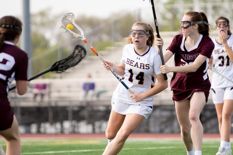 Upper Moreland's Reagan Cummins cuts across while defended by Abington's Caroline Hughes in a girls lacrosse game at Upper Moreland High School on Wednesday, May 4, 2022. The Golden Bears defeated the Ghosts 5-3.
