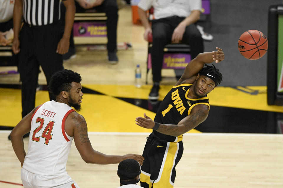Iowa guard Joe Toussaint (1) passes the ball past Maryland forward Donta Scott (24) during the first half of an NCAA college basketball game, Thursday, Jan. 7, 2021, in College Park, Md. (AP Photo/Nick Wass)