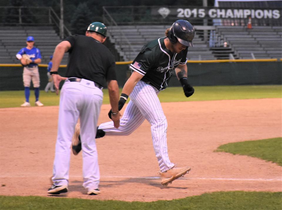Mohawk Valley DiamondDawg Garret Musey slaps hands with coach Steve Luby (left) while rounding third base with his second home run of the night in his seven-RBI game against the Watertown Rapids Friday.