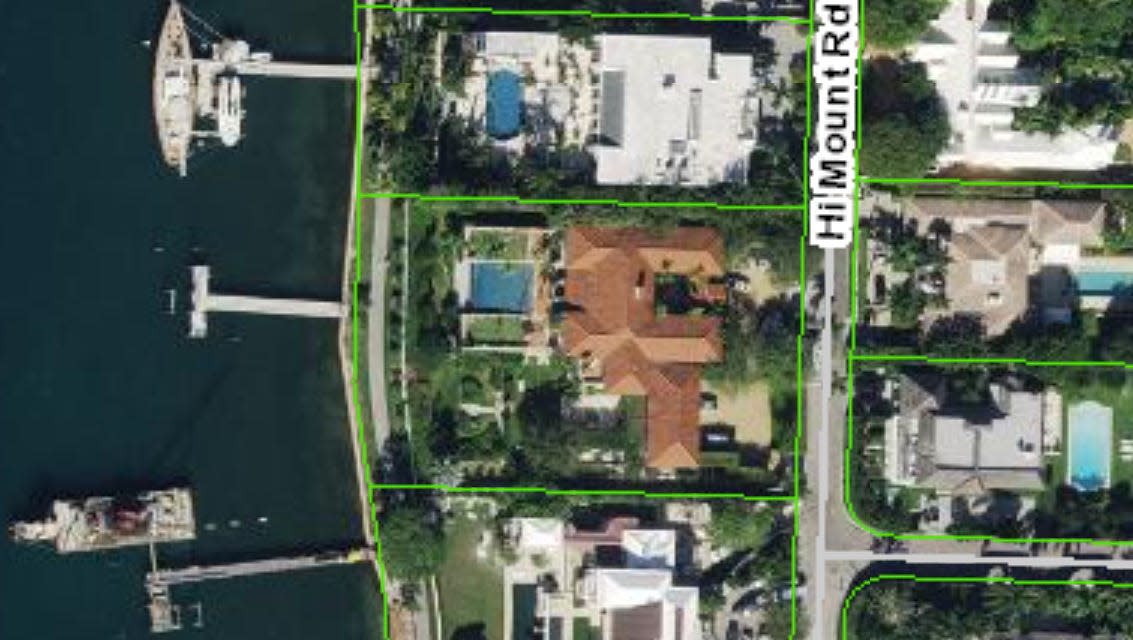 An aerial photo shows a Palm Beach lakefront house, in the center with a red roof and vacant dock, at 740 Hi Mount Road. The estate just sold privately for a price approaching $75 million.