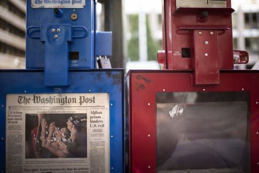 A Washington Post newspaper box (L) stands beside the empty box of competitor Washington Times (R) outside the Washington Post on August 5, 2013 in Washington, DC