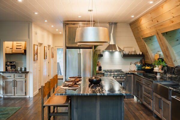 The kitchen is fitted with stainless-steel appliances, custom cabinetry, and a central island.