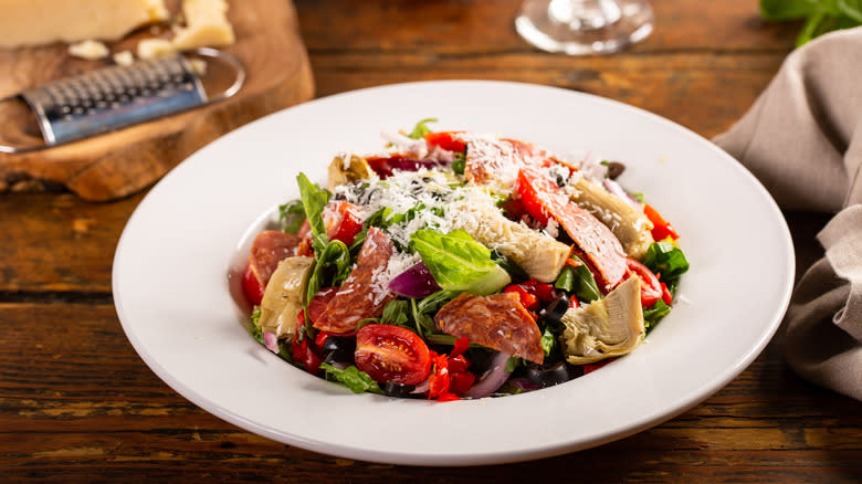 Antipasto salad in bowl with grated Parmesan