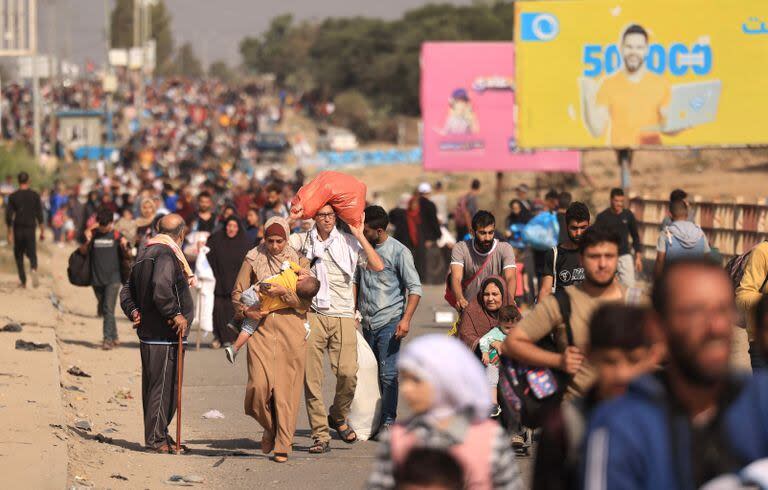 Familias palestinas que huyen de la ciudad de Gaza y otras partes del norte de Gaza hacia las zonas del sur, caminan por una carretera el 9 de noviembre de 2023