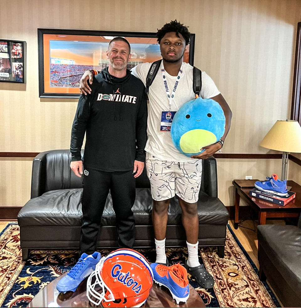 T.A. Cunningham holding his stuffed animal Baby Chop, who accompanies him on recruiting trips, with the head coach at Florida University. (Courtesy Cunningham family)