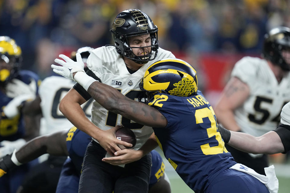 Purdue quarterback Aidan O'Connell, left, is sacked by Michigan linebacker Jaylen Harrell (32) during the first half of the Big Ten championship NCAA college football game, Saturday, Dec. 3, 2022, in Indianapolis. (AP Photo/Darron Cummings)
