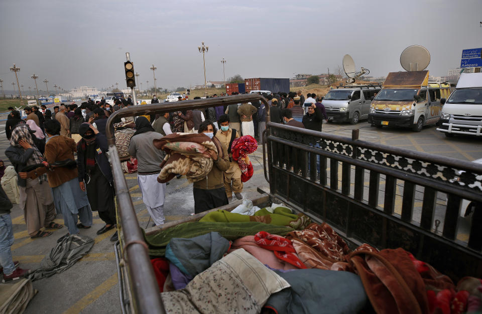 Family members of Baluch Missing Persons load their belongings into a van after end their sit-in protest, in Islamabad, Pakistan, Saturday, Feb. 20, 2021. Dozens of relatives of Baluch missing persons, allegedly taken away by security agencies from restive Baluchistan province, Saturday ended their ten-day protest sleeping in the February cold near Pakistan parliament in capital Islamabad as minster for Human Rights assured their demand for recovery of loved ones would be taken seriously. (AP Photo/Anjum Naveed)